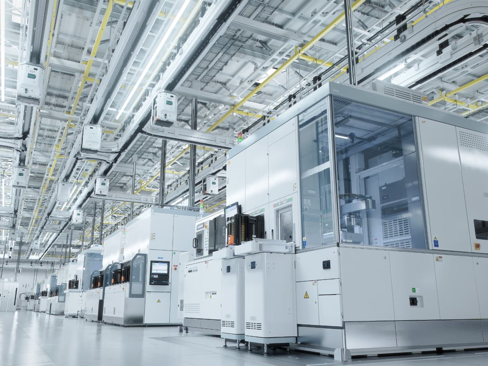 Row of semiconductor fabrication tools in a brightly lit cleanroom fab